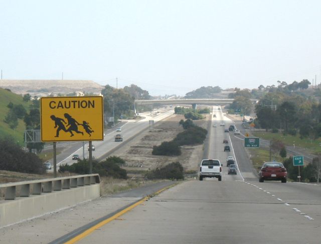 Depiction of illegal immigrants on a California 905 warning sign