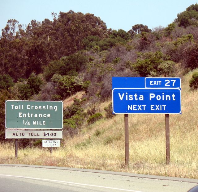 New-style service-advisory sign plus older-style toll-crossing sign on Interstate 80 eastbound in Crockett, California