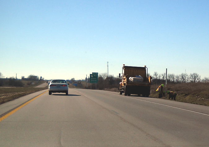 MoDOT work crew turning around an I-49 mile marker in Bates County