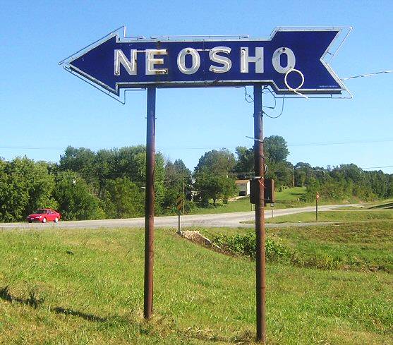 Old-style neon arrow showing the way to Neosho, Mo.