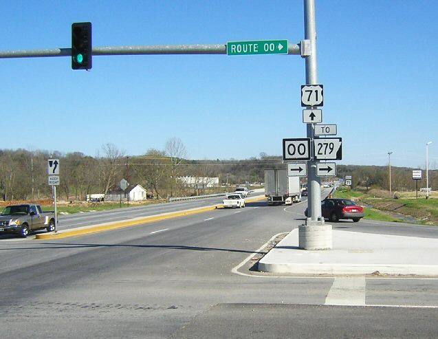 Pointer to Arkansas highway at a Missouri intersection