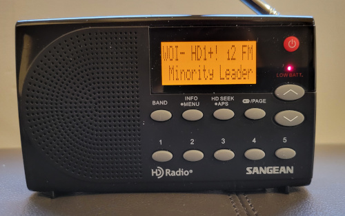 Sangean HDR-14, tuned to WOI-FM in Ames-Des Moines, Iowa, with low battery indicator LED lit in red