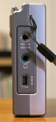 Left side of the Tecsun PL-310, showing its external antenna jack, its headphone jack, and its mini USB port