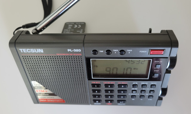 Top-down view of the Tecsun PL-320 AM/FM/SW radio showing the built-in stand